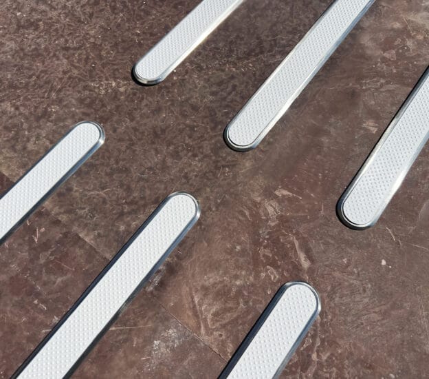 Taktila ledstavar med vita ilägg på brunt stengolv