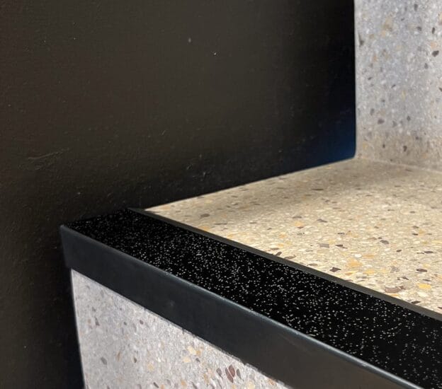 Svart kontrastmarkeringslist på stentrappa